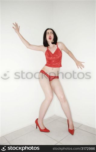 Caucasian young adult woman in lingerie making facial expression and gesturing.
