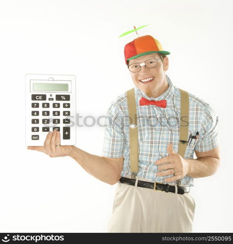 Caucasian young man dressed like nerd wearing beanie holding large calculator.
