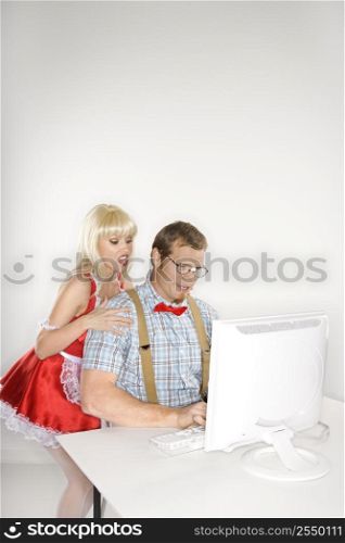 Caucasian young man dressed like nerd with Caucasian young blonde woman dressed in french maid outfit looking over shoulder.