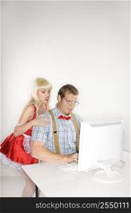 Caucasian young man dressed like nerd with Caucasian young blonde woman dressed in french maid outfit looking over shoulder.