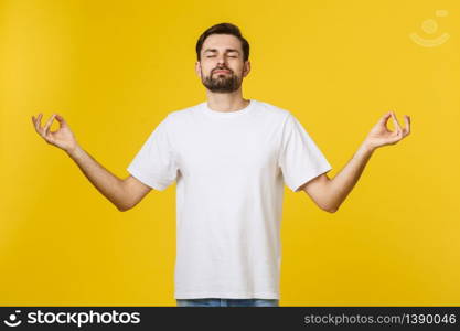 Caucasian young man white t-shirt standing isolated on gray studio background, folding fingers breath exercises process for reducing stress.. Caucasian young man white t-shirt standing isolated on gray studio background, folding fingers breath exercises process for reducing stress