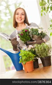 Caucasian young woman doing some gardening at home with her colorful plants