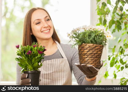 Caucasian young woman doing some gardening at home with her colorful plants