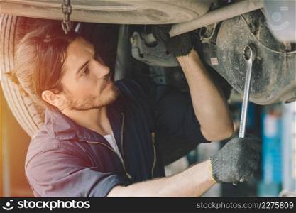 Caucasion male mechanic car service staff worker working in garage fix drive shaft problem