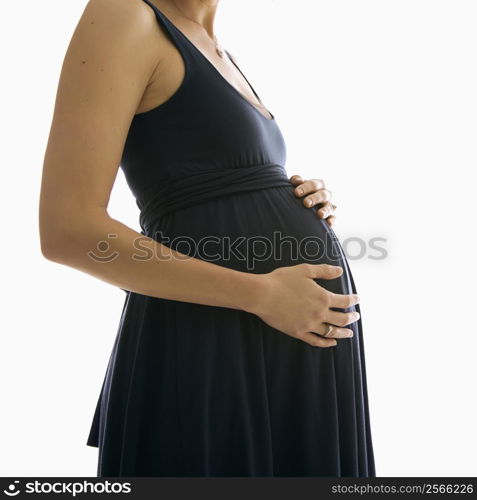 Caucasion mid-adult pregnant woman with hands on belly.