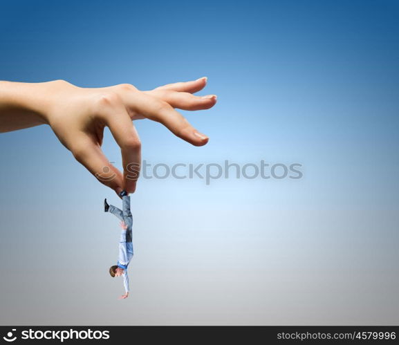 Caught businessman. Close up of human hand holding miniature of businessman