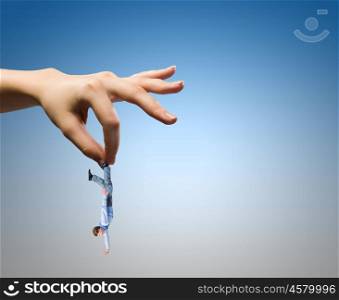 Caught businessman. Close up of human hand holding miniature of businessman