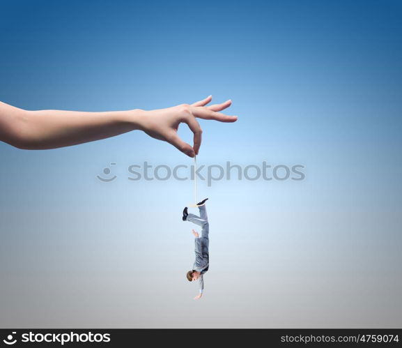 Caught businessman. Close up of human hand holding miniature of businessman