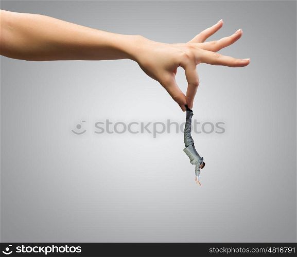 Caught businessman. Close up of human hand holding miniature of businessman