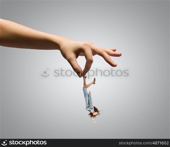 Caught businesswoman. Giant human hand holding miniature of businesswoman