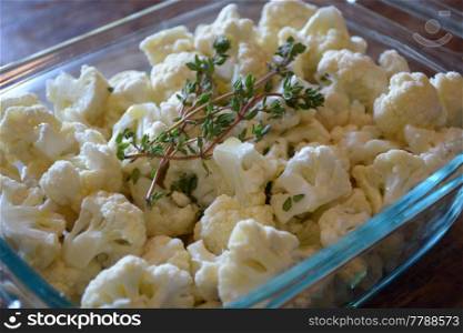 cauliflower garnished with thyme in a baking dish