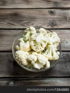 Cauliflower in a glass bowl. On a wooden background.. Cauliflower in a glass bowl.
