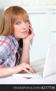 Causal redheaded woman using a white laptop computer