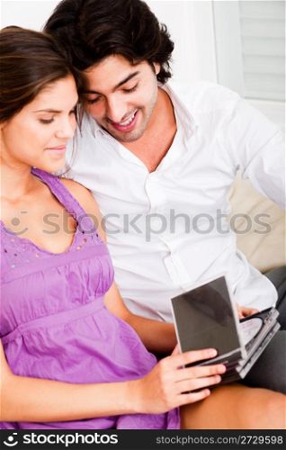 causel happy young couple looking cds by sitting on the sofa