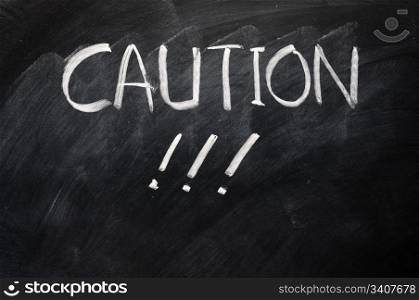 Caution written on blackboard with exclamation marks
