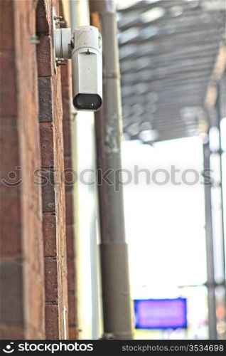 CCTV security camera on brick building watching the area