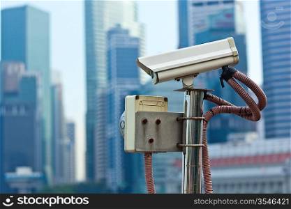 CCTV surveillance camera in Singapore with skyscapers in background