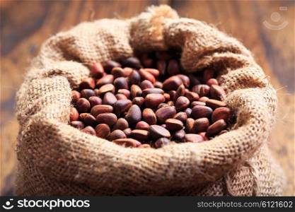 cedar nuts in a sack on wooden background