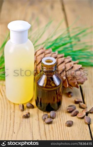 Cedar oil and lotion bottles, cedar cone, cedar nuts on the background of wooden boards