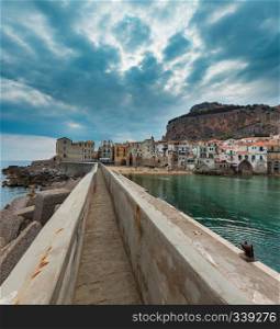 Cefalu old beautiful town beach, harbor and la Rocca view, Palermo region, Sicily, Italy. People are unrecognizable.