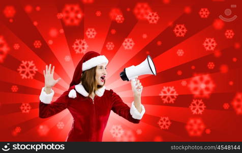 Celebrating New Year. Young attractive Santa girl listening music in headphones