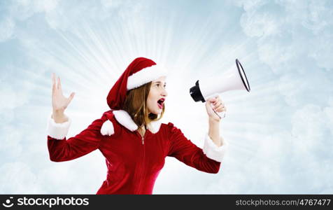 Celebrating New Year. Young attractive Santa girl listening music in headphones