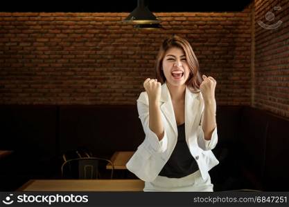 Celebrating successful young asian businesswoman with hands up. Successful young asian businesswoman with hands up