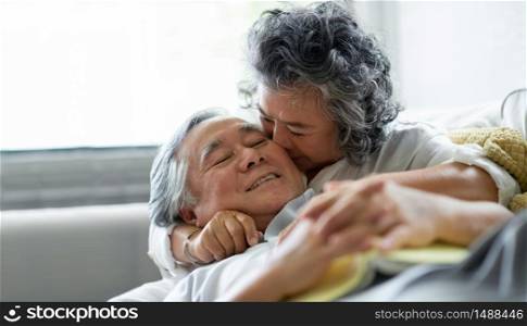 Celebrating wedding Anniversary, Asian Senior couple in love. Happy Grandmother kissing on cheek Grandfather.