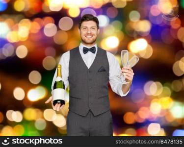 celebration, alcohol and holidays concept - happy man or waiter holding bottle of champagne and wine glasses at party over festive lights background. man with bottle of champagne and glasses at party. man with bottle of champagne and glasses at party