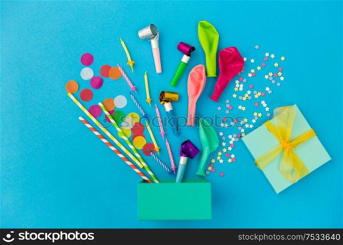 celebration and decoration concept - gift box and birthday party props on blue background. gift box and birthday party props on blue