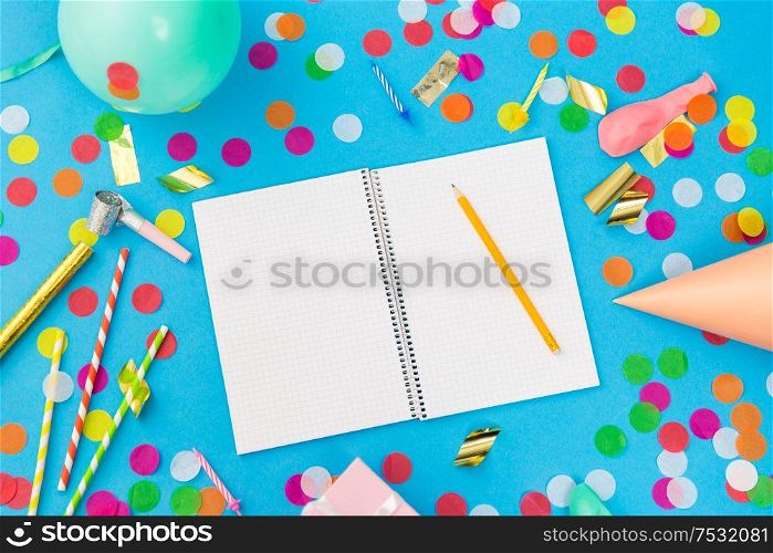 celebration and decoration concept - notebook with pencil and birthday party props on blue background. notebook with pencil and birthday party props