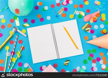 celebration and decoration concept - notebook with pencil and birthday party props on blue background. notebook with pencil and birthday party props