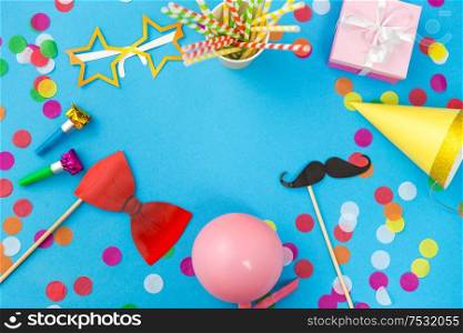 celebration and decoration concept - pink birthday gift, party props, balloons and colorful confetti on blue background. pink birthday gift and party props