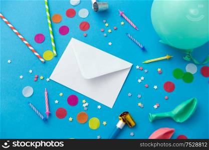 celebration and decoration concept - white postal envelope birthday party props and colorful confetti on blue background. postal envelope and birthday party props