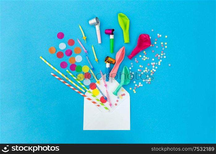celebration and decoration concept - white postal envelope birthday party props and colorful confetti on blue background. postal envelope and birthday party props