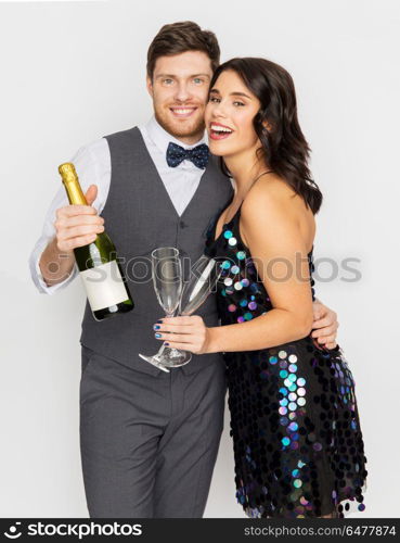 celebration and holidays concept - happy couple with bottle of non alcoholic champagne and wine glasses at party. happy couple with champagne and glasses at party. happy couple with champagne and glasses at party