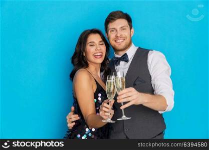 celebration and holidays concept - happy couple with glasses drinking non alcoholic champagne at party. happy couple with champagne glasses at party