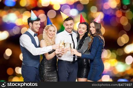 celebration and holidays concept - happy friends clinking champagne glasses at birthday party over festive lights background. friends with champagne glasses at birthday party. friends with champagne glasses at birthday party