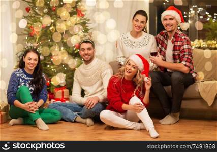 celebration and holidays concept - happy friends having christmas party together at home. friends celebrating christmas at home