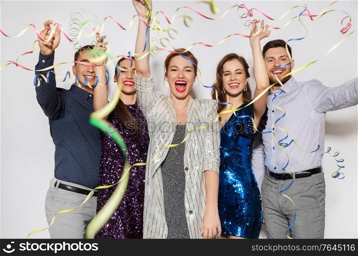 celebration and holidays concept - happy friends throwing party streamers and having fun. friends throwing party streamers and having fun