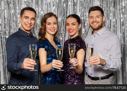 celebration and holidays concept - happy friends toasting champagne glasses at party. happy friends toasting champagne glasses at party