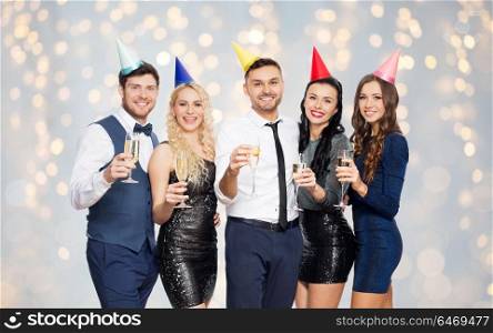 celebration and holidays concept - happy friends with champagne glasses at birthday party over festive lights background. friends with champagne glasses at birthday party