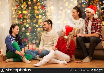 celebration and holidays concept - happy friends with glasses celebrating christmas at home party. friends celebrating christmas at home