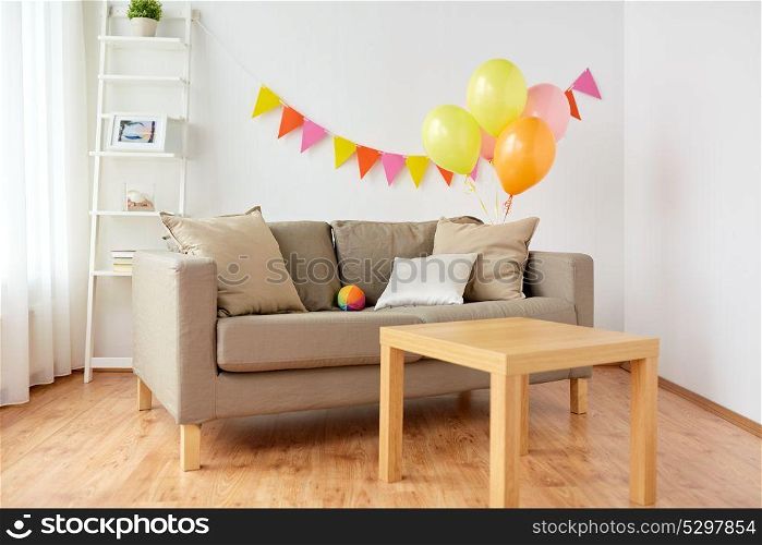celebration and interior concept - sofa with cushions and table at cozy home room decorated for birthday party. living room decorated for home birthday party
