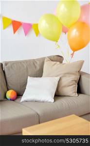 celebration and interior concept - sofa with cushions at cozy home room decorated for birthday party. sofa at home room decorated for birthday party