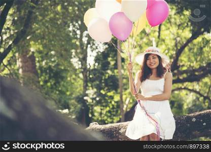 celebration and lifestyle concept - beautiful woman with colorful balloons outdoor in the park