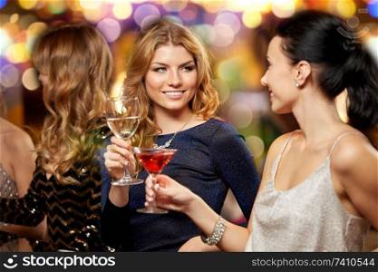 celebration, bachelorette party and holidays concept - happy women or female friends clinking glasses at night club. happy women clinking glasses at night club