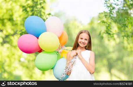 celebration, children and birthday party concept - happy girl with colorful balloons over green natural background. happy girl with balloons over natural background