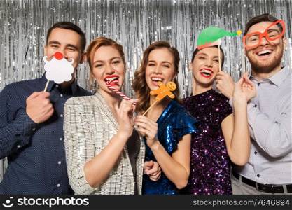 celebration, christmas and holiday concept - happy friends posing with party props. happy friends posing with christmas party props