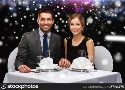 celebration, christmas, holidays and people concept - smiling couple at restaurant over night lights background